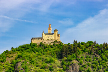 Close-up view of yellow Marksburg (Marks Castle) on the hill with vibrant green forest in Braubach, Germany