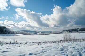 Snowy winter landscape with cloudy sky and distant village