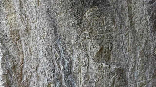 Rock engravings of Hittite warriors and symbols etched into a cliffside in Central Anatolia. Turkey