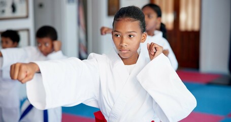Punch, lesson and girl in karate dojo for self defense training, challenge or skill with martial arts. Children, female student and group for fight, class and taekwondo club with fitness or sports © CineLens25/peopleimages.com