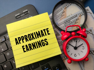 Top view banknotes and sticky note with the word APPOXIMATE EARNINGS on a blue background