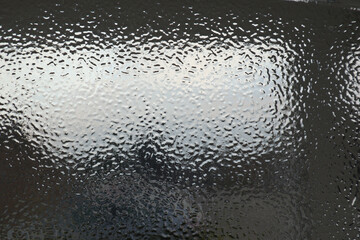 A mottled glass texture window with light and dark reflections