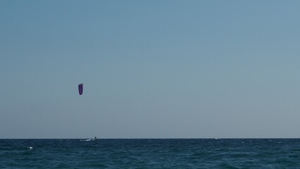 Parachuter, skydiver jumping and skydiving in parachute of yellow white black colours on parachuting cup, extreme sport active recreation on the coast sea. paragliding