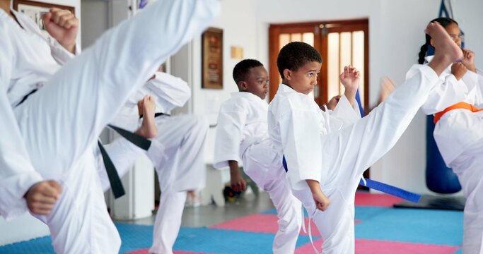 Fitness, karate and kicking with kids in class for combat, fighting or self defense training. Development, exercise or growth with children in sports dojo for martial arts lesson or practice
