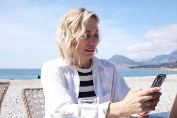 mature woman working outside in caffe on beach coast, lifestyle people concept