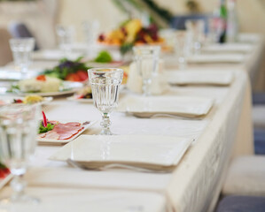 Setting the festive table. The glass is in the foreground, and there are many dishes in the back.