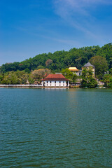 Fototapeta premium KANDY, SRI LANKA - FEBRUARY 10, 2021: View on Kandy lake and big Buddha on top of the hill. Kandy is home of The Temple of the Tooth Relic, one of the most sacred Buddhist places of worship. 