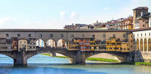 Obraz premium Ponte Vecchio spanning Arno River with colorful shops in Florence