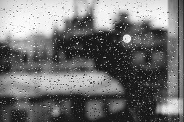 Raindrops on Window with Blurred City Buildings in Black and White