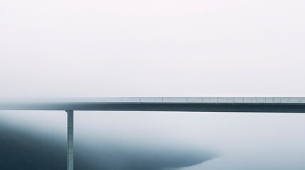 Fototapeta premium A minimalist shot of a bridge with fog rolling in behind it, reducing the distant landscape to a hazy, undefined expanse. 