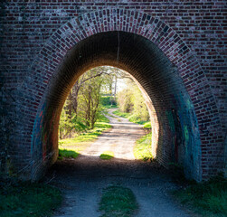 A brick archway with a path leading through it