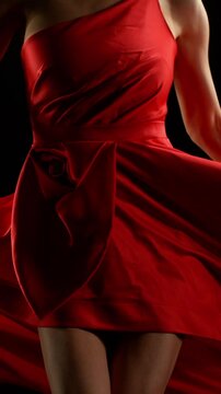 Brunette Woman in Ruby Red Dress Posing Against a Black Background . Filmed on High Speed Cinematic Camera in Super Slow Motion