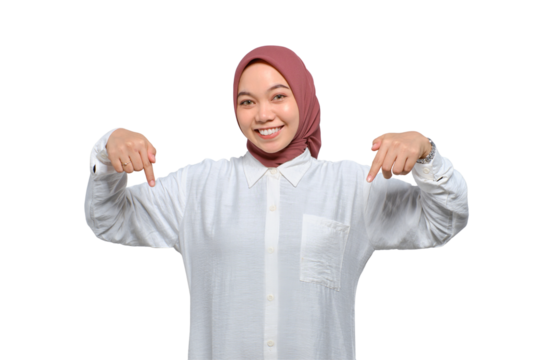 Cheerful young Asian Muslim woman pointing fingers down, showing free place for advertisement isolated on transparent background