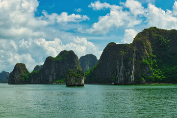 Naklejka premium HA LONG BAY, VIETNAM - JULY 19, 2022: Beautiful view of the Halong bay, Vietnam. UNESCO World Heritage. This was on a cloudy day, with many boats and spells of sunshine. during the Covid 19 pandemic. 