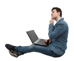 Thinking positive, young businessman sitting down on floor using laptop on his knees, dreaming with hand under chin. Imagining holiday, Network travel concept