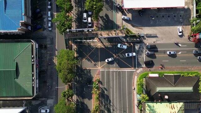Timelapse of bustling traffic along a three-way junction in Ortigas Avenue, San Juan City, Philippines - aerial top-down