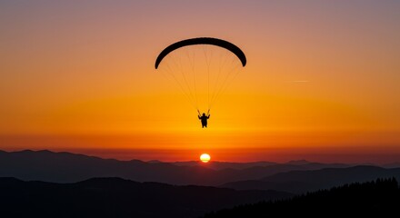 Paraglider Soaring at Sunset - Silhouette of a paraglider flying against a vibrant orange sunset over a mountain range. Peaceful and adventurous scene