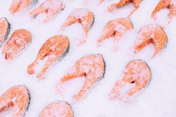 Multiple fresh salmon fillets on ice, close-up view.