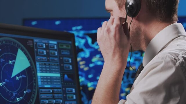 Professional air traffic controller in the control tower. Aircraft control officer works using radar, computer navigation and digital maps. Close-up portrait.
