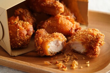 Close-up of crispy golden-brown fried chicken with crunchy coating, served rustic-style in warm lighting with rich texture and juicy detail