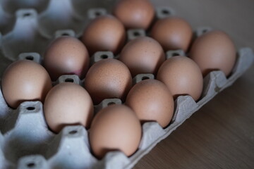 Brown chicken eggs neatly arranged in a paper tray, ready for cooking
