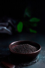 Black Plate with Peppercorns on Dark Background. High quality photo