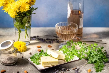 Fotobehang Eetkamer Gourmet cheese with herbs, rose wine, and yellow flowers creating a luxurious culinary scene  © Victoria Kondysenko
