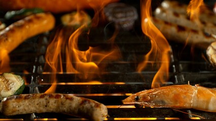 Close-up of Barbeque Grill with Various Meats and Roaring Flames