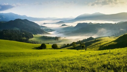 Naklejka premium Paisaje de valle brumoso con campo verde y montañas brumosas; hermoso fondo de pantalla matutino; fondo pintoresco inspirador para pancartas o postales, espacio de copia, diseño de lugar, inspiración