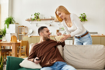 Cozy evening at home with a couple sharing popcorn and laughter in a modern living space