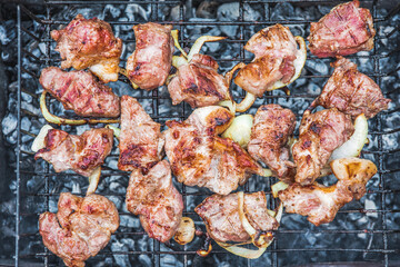 Close-up. Juicy pieces of kebab meat are grilled outdoors.