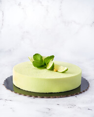 Green Mousse Cake with Lime and Mint. Front View on Marble Background with Copy Space.