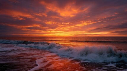 Fototapeta premium A vibrant sunset over the ocean, with the sea turning a warm orange color and the sky ablaze with golden and red hues