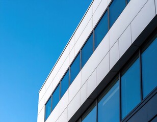 Obraz premium Modern Office Building Facade With White Panels And Glass Windows Against Blue Sky