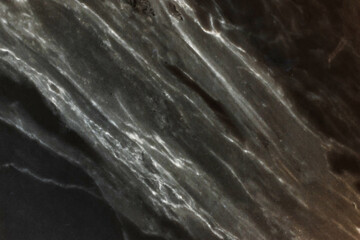 Abstract image of dark marble featuring prominent, contrasting veins. Unique texture is ideal for backgrounds, overlays, or artistic projects
