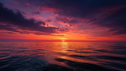 The sea bathed in deep orange hues as the sun sets, with the sky lit up in shades of red and pink, creating a stunning natural masterpiece