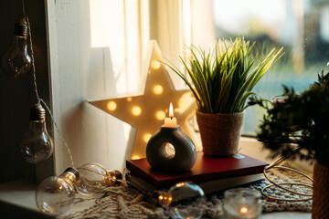 A cozy windowsill adorned with glowing candles and elegant home decor, creating a warm and inviting atmosphere. Perfect for themes of relaxation, hygge, and timeless interior beauty