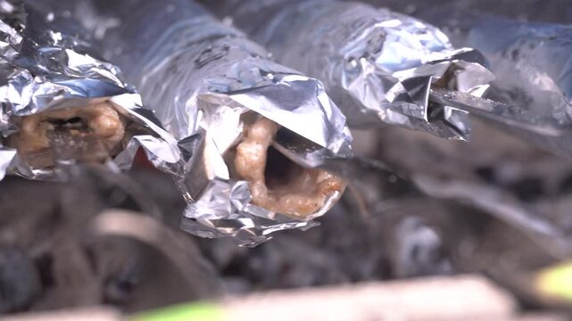 lula kebabs grilling on metal skewers, rotating for uniform browning over high heat, releasing savory aromas