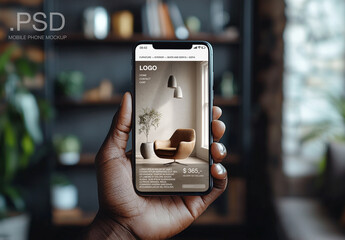 A hand holding a smartphone up in front of a living room background. Mobile design header.