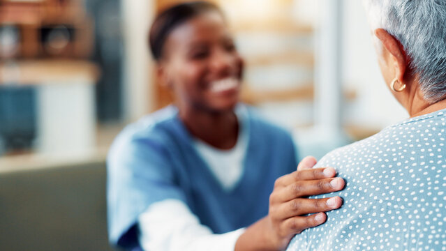 Senior woman, nurse and hand on shoulder for support, healthcare and medical wellness in home. Retirement, patient and comfort with caregiver in living room for help, kindness and empathy with trust