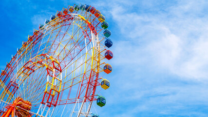 A fragment of a Ferris wheel against the sky in an amusement park. Panoramic view