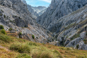 Stunning panoramic view of the dramatic rocky peaks and deep valleys of the Picos de Europa National Park in  Spain, showcasing rugged cliffs, narrow gorges. Popular destination for hiking, adventure.