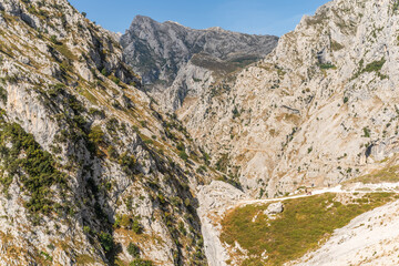 Stunning panoramic view of the dramatic rocky peaks and deep valleys of the Picos de Europa National Park in  Spain, showcasing rugged cliffs, narrow gorges. Popular destination for hiking, adventure.