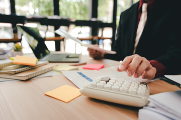 Accountant working at desk using calculator to calculate company's annual financial and tax report....