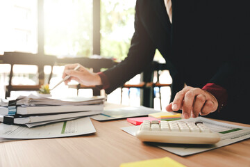 Accountant working at desk using calculator to calculate company's annual financial and tax report....
