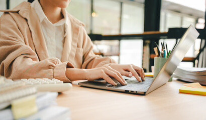 Close-up portrait typing keyboard on laptop computer. Working online on white table at office....