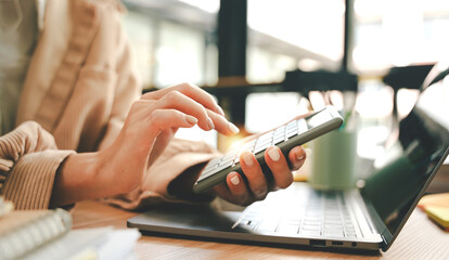 Accountant working at desk using calculator to calculate company's annual financial and tax report....