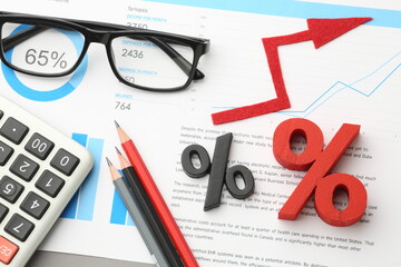 calculator and pen with blue business charts, graphs, information and reports background for...