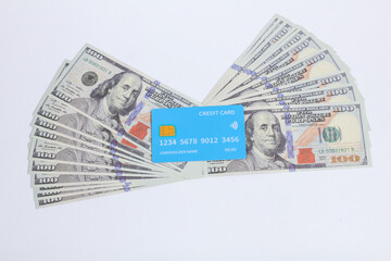 credit card on top of a stack of hundred dollar bills