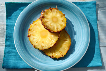 Slice of pineapple on a blue plate